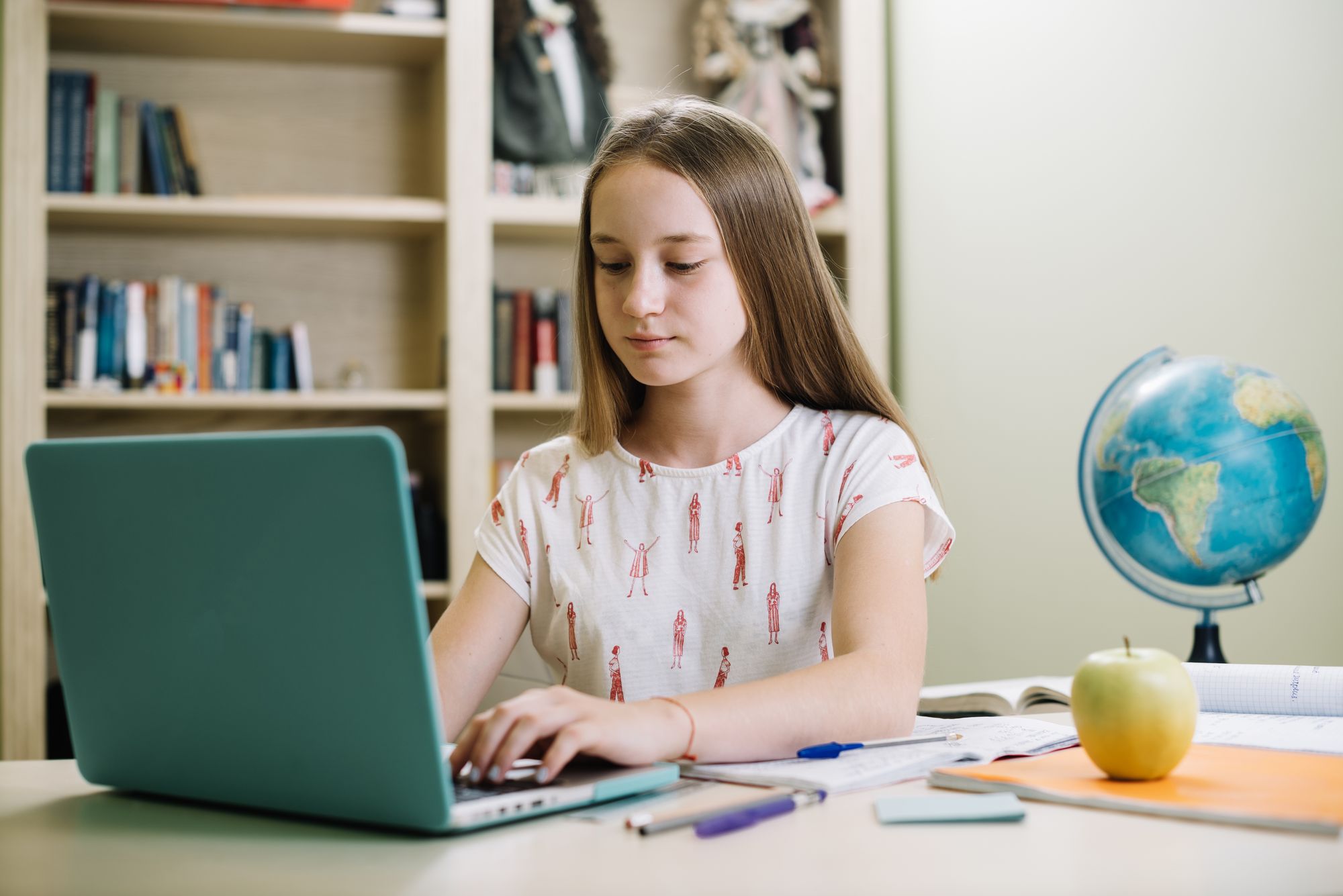 Dziewczynka odrabiająca lekcje na laptopie