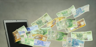 Zdjęcie pieniędzy wylatujących z ekranu laptopa