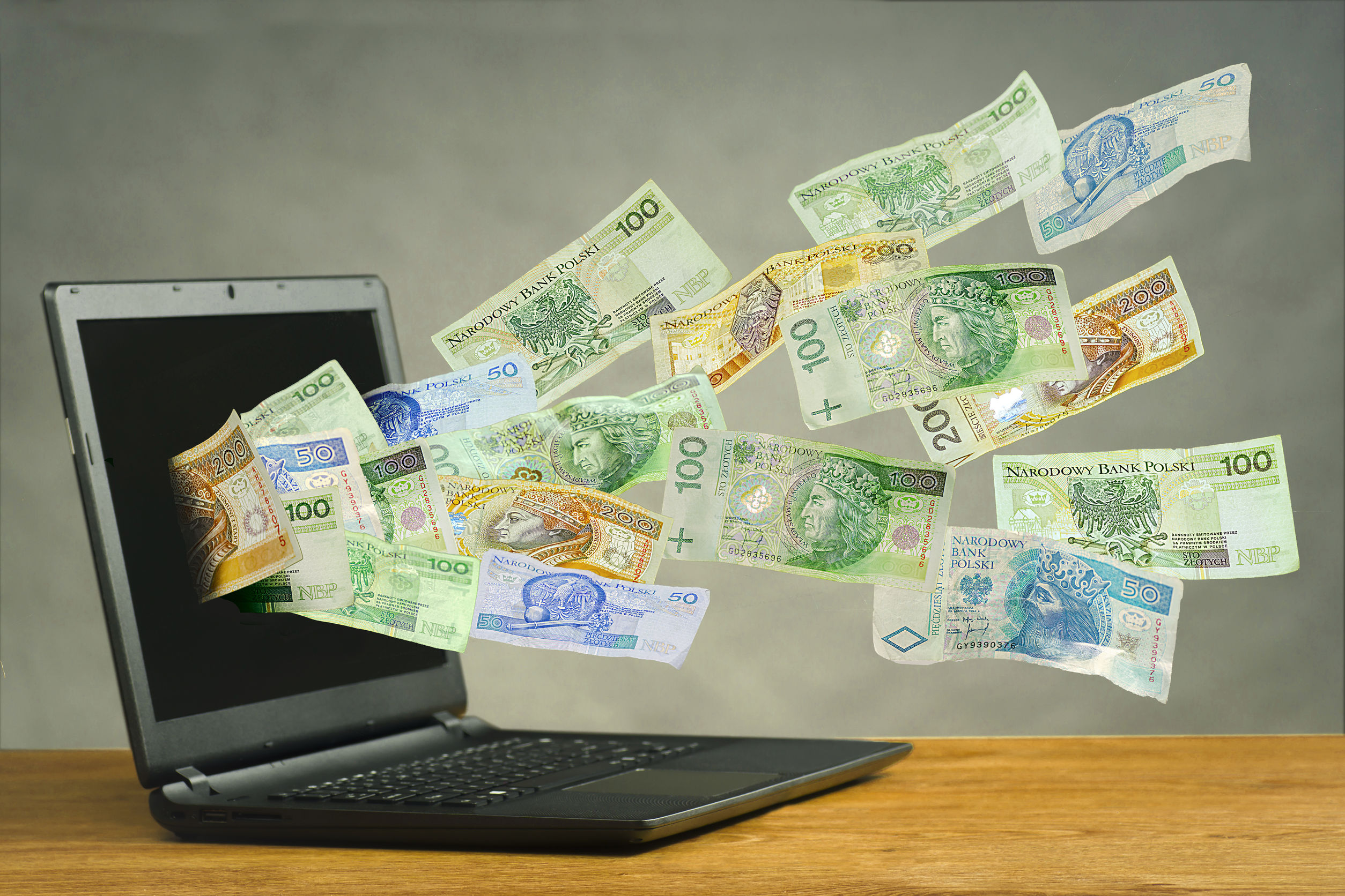 Zdjęcie pieniędzy wylatujących z ekranu laptopa